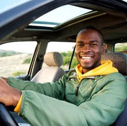 Young man smiling while driving 