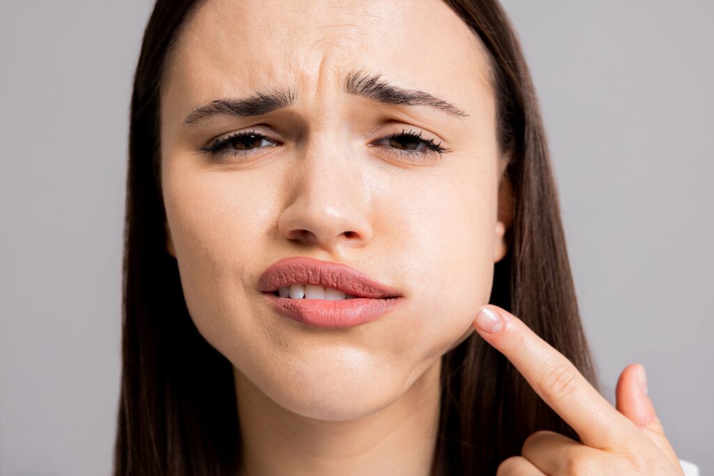 Woman pointing to her swollen cheek